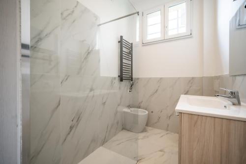 a white bathroom with a sink and a toilet at Renzo & Lucia Living Lake in Malgrate