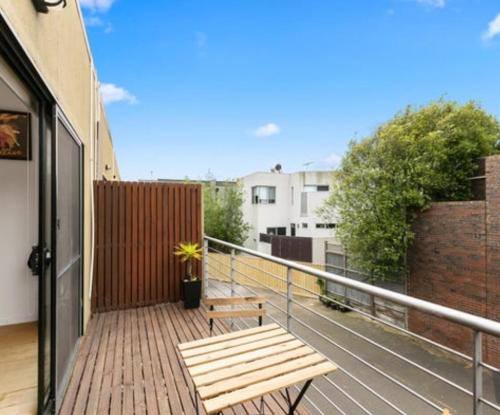 a wooden bench sitting on the balcony of a building at Ascot Vale - Lovely 2 bedroom townhouse close to everything! in Ascot Vale