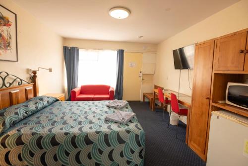 a hotel room with a bed and a desk at Bunbury Motel and Apartments in Bunbury