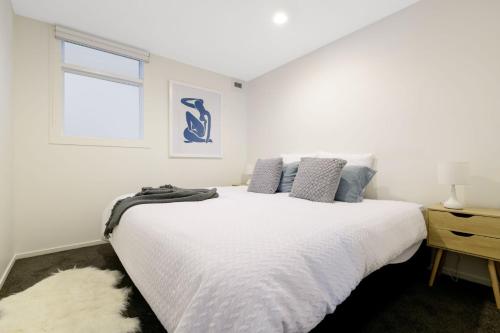 マウント・マウンガヌイにあるCentral Mount Apartment, Quiet and Spacious with Poolの大きな白いベッドと窓のある寝室