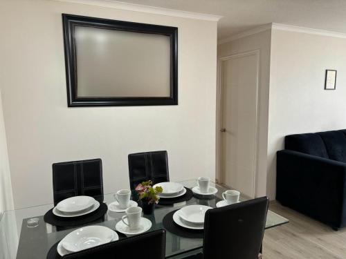 a dining room with a table and chairs and a mirror at Departamento en condominio in Pucón