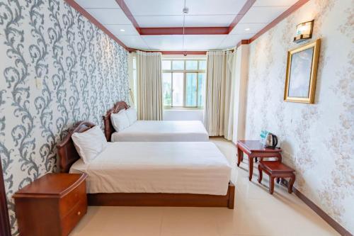 a bedroom with two beds and a window at Phúc Đạt Hotel in Vung Tau
