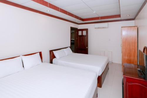 a bedroom with two beds and a tv at Phúc Đạt Hotel in Vung Tau