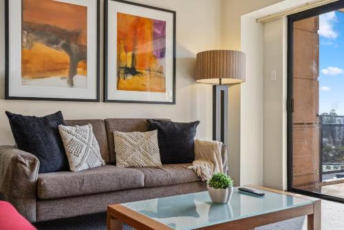 a living room with a couch and a table at Cozy 2-Bedroom Apartment with City Views in Perth