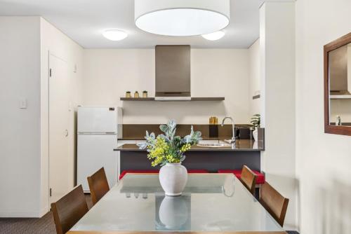 a kitchen with a table with a vase of flowers on it at Cozy 2-Bedroom Apartment with City Views in Perth