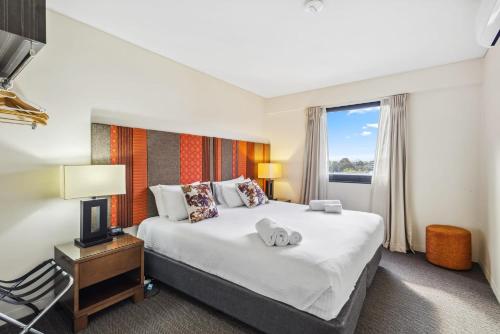 a hotel room with a bed and a window at Cozy 2-Bedroom Apartment with City Views in Perth