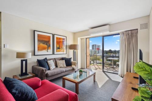a living room with a couch and a table at Cozy 2-Bedroom Apartment with City Views in Perth