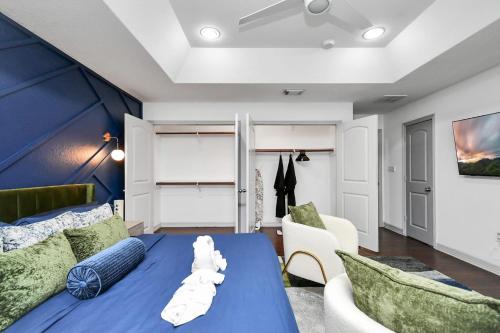 a bedroom with a blue bed and two chairs at ProlificSuites Escape - Stylish Spaces & Prime Location in Houston
