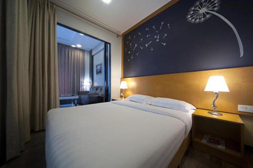 a bedroom with a large white bed with a blue wall at 16celsius at Kea Farm Brinchang in Brinchang