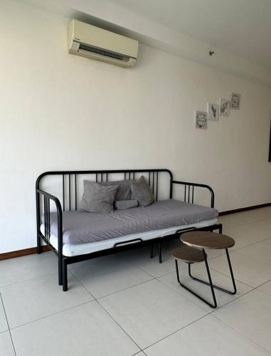 a bed in a room with a bench and a stool at The Landmark Comfort Relax Spacious Sea View By IZ in Tanjong Tokong