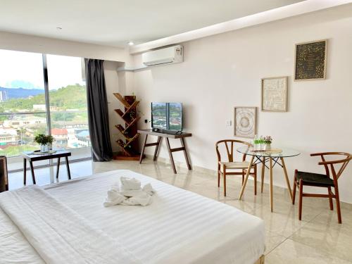 a bedroom with a bed and a table and chairs at Deco Home @ Aru Suites in Kota Kinabalu