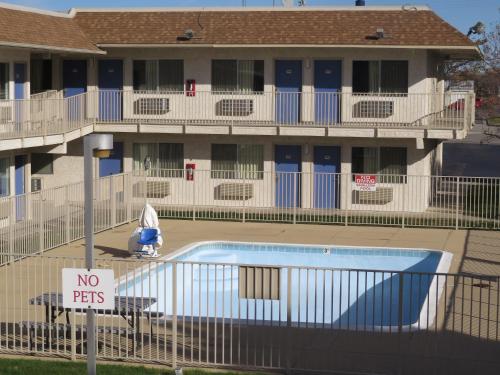 a no pets sign in front of a building with a pool at Motel 6-Mitchell, SD in Mitchell