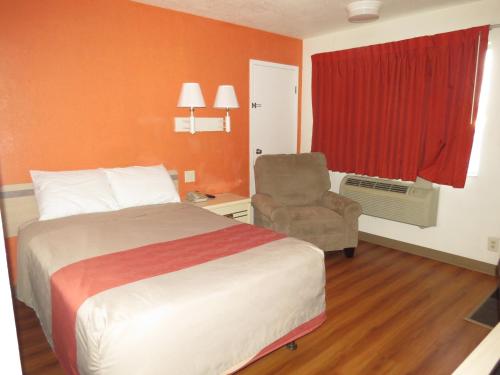 a hotel room with a bed and a chair at Motel 6-Mitchell, SD in Mitchell