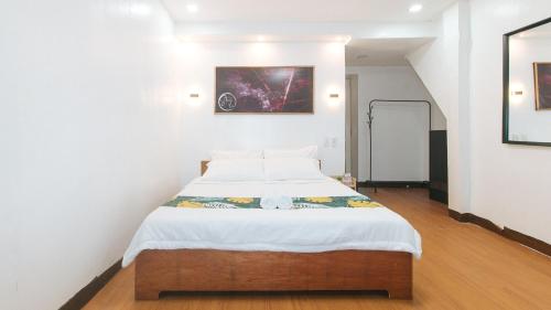 una camera da letto con un letto grande con lenzuola bianche di Stay Inn Station 1 Boracay by RedDoorz a Boracay