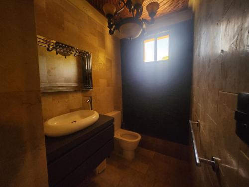a bathroom with a sink and a toilet and a window at Villa Tesoros del Mar - Luxury Beachfront Villa with Natural Pool, Jacuzzi, Mountain Views, Yoga, BBQ, Wi-Fi, Pet & Family Friendly, Barahona Adventures in El Arroyo