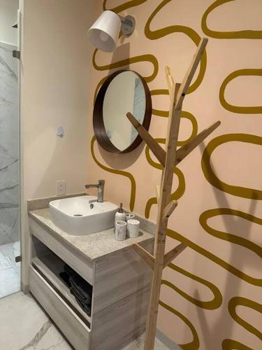 a bathroom with a sink and a mirror on the wall at Biulu Apartment at Tangolunda Bay in Tangolunda
