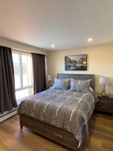 a bedroom with a bed and a large window at Motel 400 & Suites in Innisfil