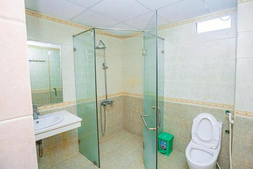 a bathroom with a shower and a toilet and a sink at Biển Đợi Hotel SS by BAY LUXURY in Sầm Sơn