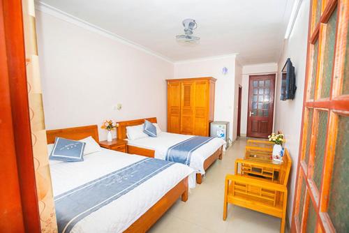 a hotel room with two beds and a table at Biển Đợi Hotel SS by BAY LUXURY in Sầm Sơn