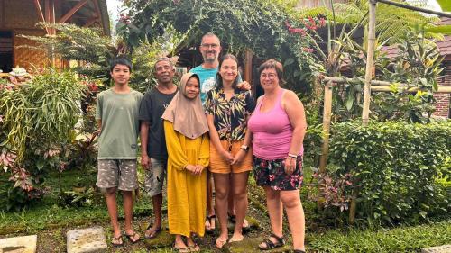 a family posing for a picture in a garden at Ariel Bungalow Tetebatu in Tetebatu