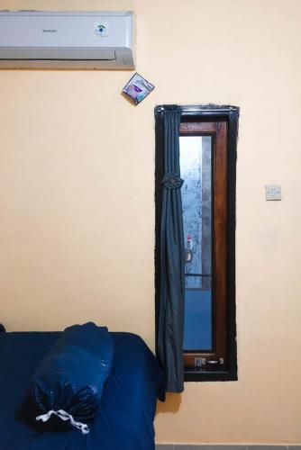 a bedroom with a mirror and a bed and a window at Angel homestay and shop in Dompu