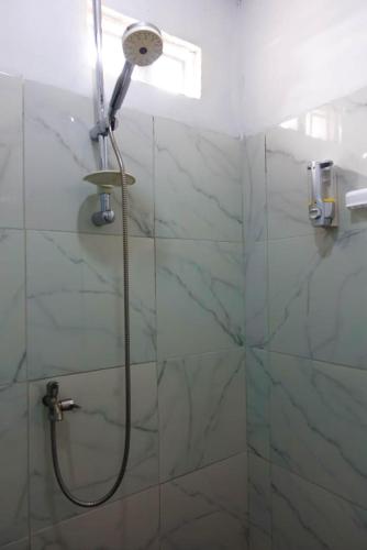 a shower with a shower head in a bathroom at Angel homestay and shop in Dompu