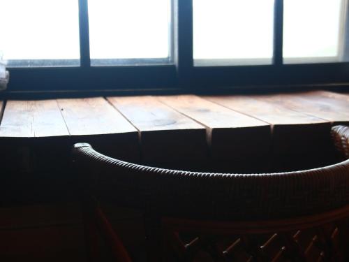 a chair in front of a table with windows at Pension Mon Repos in Nozawa Onsen