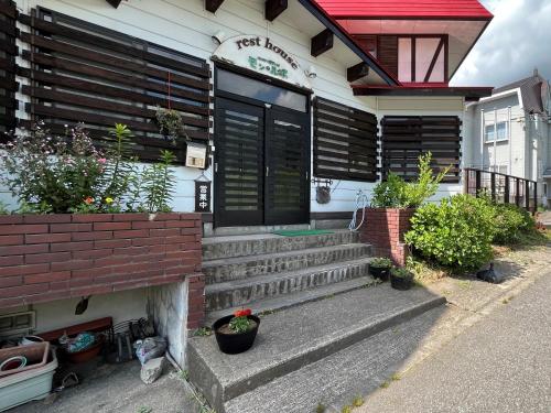 a house with stairs and plants on the front of it at Pension Mon Repos in Nozawa Onsen