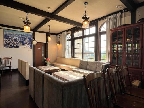 a living room with a couch and a window at Pension Mon Repos in Nozawa Onsen