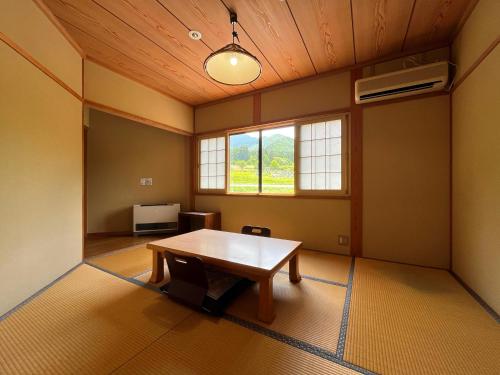 an empty room with a table and a window at Pension Mon Repos in Nozawa Onsen