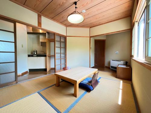 a dining room with a wooden table in a room at Pension Mon Repos in Nozawa Onsen