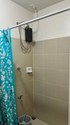 ein Bad mit Dusche und Duschvorhang in der Unterkunft Cozy Studio Condo Unit at Fullerton Suites in Silang