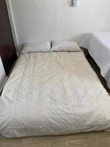 a white bed with two pillows on top of it at Casa Tipo Villa, Piscina, Playas De RSJ a 4 min in Río San Juan