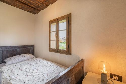 a small bedroom with a bed and a window at Kolpa Holidays in Gradac