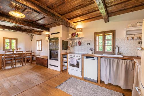 a kitchen with white appliances and a wooden ceiling at Kolpa Holidays in Gradac