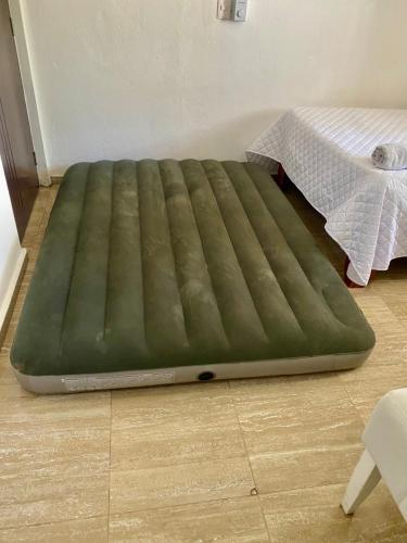 a large green mattress on the floor next to a bed at Casa Tipo Villa, Piscina, Playas De RSJ a 4 min in Río San Juan
