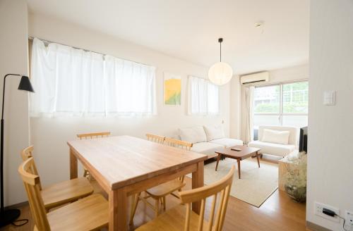 a living room with a wooden table and chairs at Mi-APT MIDORI in Tokyo