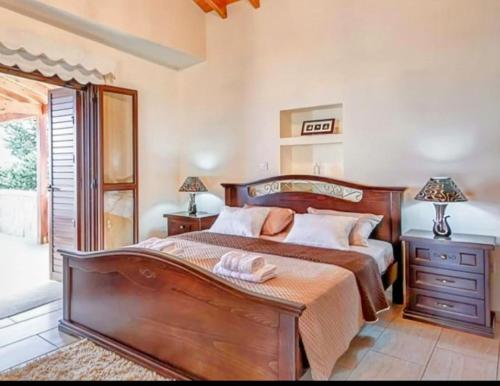 a bedroom with a large wooden bed with two lamps at Villa Elizabeth in Limassol