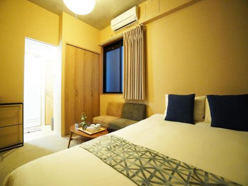 a hotel room with a bed and a couch at MUSUBI HOTEL Kyoto Shijo-Omiya in Kyoto