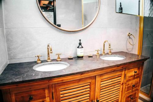 a bathroom with two sinks and a large mirror at Gorgeous 3 bedroom raked ceiling cabin on the hill in Blackbutt