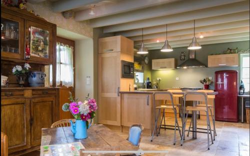 une cuisine avec une table, des chaises et un réfrigérateur dans l'établissement La petite maison dans la campagne, à Massingy-lès-Vitteaux