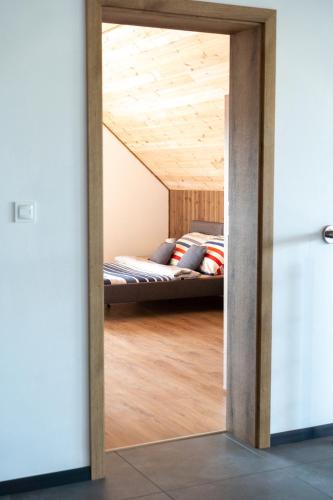 a bedroom with a bed through a doorway at Pokoje Gościnne Fuksja in Nowęcin