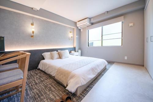 a bedroom with a large white bed and a window at Hotel Neiraku in Nara