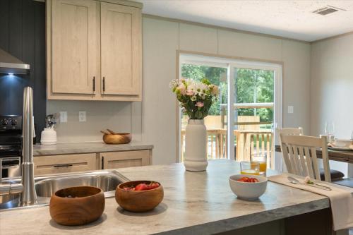 a kitchen with a table with a vase of flowers on it at Ichetucknee Springs 2 MI - Fire Pit Pavilion & Grill in Fort White
