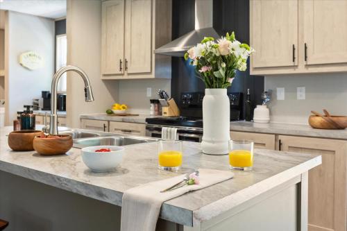 a kitchen counter with two glasses of orange juice and a vase of flowers at Ichetucknee Springs 2 MI - Fire Pit Pavilion & Grill in Fort White