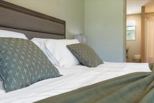 a white bed with two pillows on top of it at Ichetucknee Springs 2 MI - Fire Pit Pavilion & Grill in Fort White
