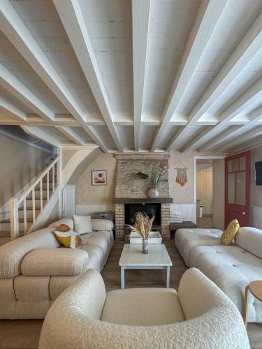 a living room with couches and a fireplace at Titmaë in Ouistreham