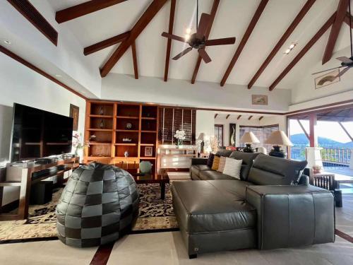 a living room with a couch and a ceiling fan at Patong Seaview Luxury Villa Penda in Patong Beach