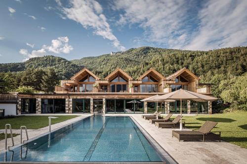 a house with a pool and mountains in the background at Bachmanngut in St. Wolfgang