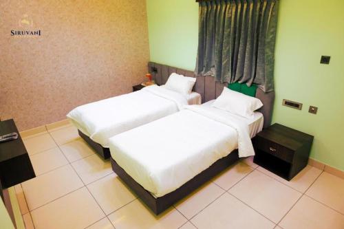 a bedroom with two beds and a window at Siruvani Residency - Near Isha Foundation Coimbatore in Alāndurai